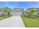 Two-story home features a two-car garage, well-manicured lawn, and tropical landscaping at 5540 Summit Gln, Bradenton, FL 34203