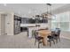 Kitchen with black cabinetry, stainless steel appliances, granite counters, seating at the island, and pendant lighting above at 5540 Summit Gln, Bradenton, FL 34203