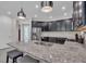 Open concept kitchen with a large granite island with barstool seating, pendant lights, and stainless steel appliances at 5540 Summit Gln, Bradenton, FL 34203