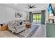 Bright living room with tile floors, a ceiling fan, a comfortable couch, and a view of the green yard through sliding glass doors at 5540 Summit Gln, Bradenton, FL 34203