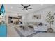 Bright living room with large sectional sofa, ceiling fan, and open to the kitchen with an island and stainless appliances at 5540 Summit Gln, Bradenton, FL 34203