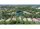 An aerial view of a home situated on a verdant lot, surrounded by a pond, lush trees, and a golf course in the distance at 5839 Los Verdes Ct, Bradenton, FL 34210