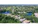 Stunning aerial view of property with lush landscaping, tile roof, and a sparkling pool, backing onto serene lakes and golf course at 5839 Los Verdes Ct, Bradenton, FL 34210