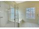 Bright bathroom featuring a glass-enclosed shower, a soaking tub, and decorative wallpaper at 5839 Los Verdes Ct, Bradenton, FL 34210