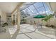 A screened courtyard featuring a fountain, lounge chairs, potted plants and an umbrella for relaxing outdoors at 5839 Los Verdes Ct, Bradenton, FL 34210