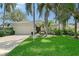 Charming single-story home featuring a well-manicured lawn, a two-car garage, and vibrant landscaping with palm trees at 5839 Los Verdes Ct, Bradenton, FL 34210