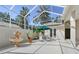Enclosed patio with a fountain, umbrella, table, chairs, and palm trees at 5839 Los Verdes Ct, Bradenton, FL 34210