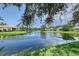 Picturesque view of a tranquil pond reflecting the surrounding homes and lush greenery under a sunny sky at 5839 Los Verdes Ct, Bradenton, FL 34210