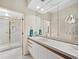 Elegant bathroom with a long vanity, mirrored wall, and a glass-enclosed shower offering a luxurious spa-like experience at 615 Dream Island Pl # 105, Longboat Key, FL 34228