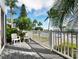 Inviting outdoor deck with seating overlooking a scenic view, surrounded by lush greenery and swaying palms at 615 Dream Island Pl # 105, Longboat Key, FL 34228
