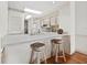 Compact kitchen featuring white cabinets, a breakfast bar with seating, and essential appliances for convenient meal preparation at 615 Dream Island Pl # 105, Longboat Key, FL 34228