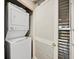 Convenient laundry room with stacked washer and dryer units, plus a window for ventilation, optimizing space and functionality at 615 Dream Island Pl # 105, Longboat Key, FL 34228