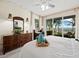 Comfortable main bedroom with a dresser, a desk, and sliding glass doors offering tranquil views of the waterway at 615 Dream Island Pl # 105, Longboat Key, FL 34228