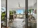 Bright patio features tiled floors, comfortable seating, and scenic views of the waterway and swaying palm trees at 615 Dream Island Pl # 105, Longboat Key, FL 34228