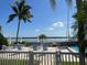 Relaxing pool area with lounge chairs, umbrellas, and views of the serene bay surrounded by palm trees at 615 Dream Island Pl # 105, Longboat Key, FL 34228