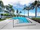 Bright, inviting community pool with clear blue water, steps and rail, in a resort-style complex, enhanced by palm trees at 615 Dream Island Pl # 105, Longboat Key, FL 34228