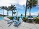 Relax poolside with modern patio furniture, a grill, and serene water views, perfect for outdoor relaxation at 615 Dream Island Pl # 105, Longboat Key, FL 34228