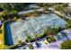 Well-maintained tennis courts viewed from above with manicured landscaping, offering recreational opportunities at 615 Dream Island Pl # 105, Longboat Key, FL 34228