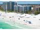 Aerial view of beach and condos on a bright sunny day with white sandy shores at 6312 Midnight Pass Rd # 102S, Sarasota, FL 34242