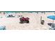 Red ATV sits on beach near chairs, umbrellas, tents and people enjoying the coast at 6312 Midnight Pass Rd # 102S, Sarasota, FL 34242