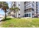 Exterior view of beachfront condo building with balconies and landscaped grounds at 6312 Midnight Pass Rd # 102S, Sarasota, FL 34242