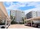 Exterior of complex with brick parking area under carports and well maintained landscaping at 6312 Midnight Pass Rd # 102S, Sarasota, FL 34242
