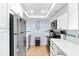 Bright kitchen featuring white cabinetry, stainless steel appliances, and tile floors at 6312 Midnight Pass Rd # 102S, Sarasota, FL 34242