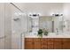 Bright bathroom features a glass enclosed shower, large mirrors, double sink vanity, and plenty of counter space at 7419 Birds Eye Ter, Bradenton, FL 34203
