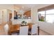Bright dining room with wooden table, white chairs, and view to the kitchen and lovely outdoor plants at 7419 Birds Eye Ter, Bradenton, FL 34203