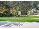 Welcoming community entrance with a decorative sign surrounded by vibrant flowers and mature trees at 7419 Birds Eye Ter, Bradenton, FL 34203