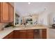 Open kitchen boasts light countertops, wooden cabinetry, and a breakfast bar overlooking the living area at 7419 Birds Eye Ter, Bradenton, FL 34203