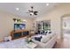 Bright living room with a ceiling fan, tile flooring, and a sliding glass door leading to the lanai at 7419 Birds Eye Ter, Bradenton, FL 34203