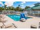 Community swimming pool with lounge chairs, clear blue water, and a covered area for relaxation at 7419 Birds Eye Ter, Bradenton, FL 34203