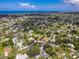 Aerial view of a charming neighborhood with houses near the ocean under a bright blue sky at 760 Azure Rd, Venice, FL 34293