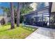 Inviting backyard featuring a screened-in lanai and well-maintained grassy area, perfect for outdoor relaxation at 760 Azure Rd, Venice, FL 34293