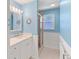 Bright blue bathroom with vanity, wainscotting, and shower stall at 760 Azure Rd, Venice, FL 34293