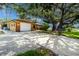 Well-maintained home with a spacious driveway, one-car garage, and mature trees at 760 Azure Rd, Venice, FL 34293