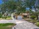 Well-maintained home with a spacious driveway, one-car garage, and mature trees providing ample shade at 760 Azure Rd, Venice, FL 34293