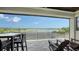Covered balcony features a table and chairs and overlooks a lake at 7665 Haddington Cv, Bradenton, FL 34202
