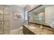 Bathroom featuring granite counters, walk-in shower with decorative tile, and natural light at 7665 Haddington Cv, Bradenton, FL 34202