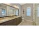 Bathroom with a double vanity, large mirror, walk-in shower and privacy window at 7665 Haddington Cv, Bradenton, FL 34202