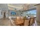 Elegant dining room with modern chandelier and open access to a lanai with water views at 7665 Haddington Cv, Bradenton, FL 34202