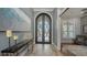 Elegant foyer with decorative table, art and double arched doorway at 7665 Haddington Cv, Bradenton, FL 34202