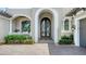 Elegant front entrance with arched doorway, beautiful plants, and decorative flower boxes at 7665 Haddington Cv, Bradenton, FL 34202