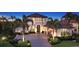 Well-lit home with manicured landscaping, paver driveway, and a three-car garage at 7665 Haddington Cv, Bradenton, FL 34202