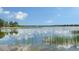 Scenic lake view with calm waters reflecting the blue sky and shoreline at 7665 Haddington Cv, Bradenton, FL 34202