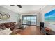 Living room with sliding glass doors to patio with lake views and comfortable seating at 7665 Haddington Cv, Bradenton, FL 34202