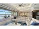 Spacious living area with large sofa, ceiling fan, and sliding glass doors that open to a patio and water view at 7665 Haddington Cv, Bradenton, FL 34202