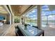 Covered patio area blending indoor/outdoor living, featuring a pool, outdoor seating, and a serene lake view at 7665 Haddington Cv, Bradenton, FL 34202
