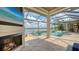 Spacious screened-in patio featuring a fireplace, tv, and views of the pool and tranquil lake at 7665 Haddington Cv, Bradenton, FL 34202